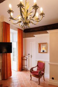 a living room with a chair and a chandelier at Domaine de la Rocque in Liorac