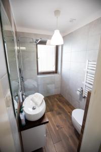a white bathroom with a sink and a toilet at Hacjenda in Boszkowo-Letnisko +21 photos