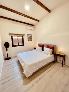 a bedroom with a large white bed and a table at Villa 'Le Grand France' in Sainte-Marie