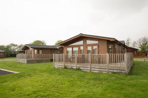 a house with a fence in front of it at Sandy Glade Holiday Park in Burnham on Sea