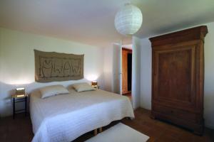 a bedroom with a large white bed and a chandelier at Villa Sainte-Claire maison avec studio in Hyères +15 photos