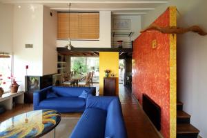 a living room with blue couches and a red wall at Villa Sainte-Claire maison avec studio in Hyères