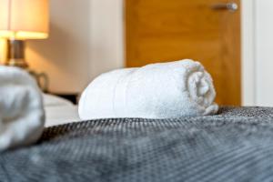 een rol toiletpapier zittend op een bed bij Luxury 1-Bed Apartment in JQ, Sleeps 3, Parking & Netflix, Ideal for contractors in Birmingham +27 foto's