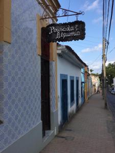 een bord aan de zijkant van een gebouw op een straat bij Pousada Alquimia in Olinda