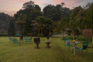 a group of chairs and tables in a yard at SaffronStays Sylvan Farms - 3BR eco-luxury villa with birdwatching, trekking and organic farming in Mount Abu in Delmāra +37 photos