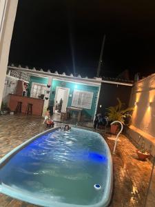 ein Kind in einem Pool in der Nacht in der Unterkunft Centro caiçara in Praia Grande