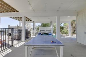 a ping pong table on a covered patio with a table at Beachfront Paradise with Pool on St George Island! in St. George Island