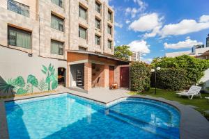 a swimming pool in front of a building at Chairu Eco Hotel in Santa Cruz de la Sierra