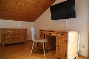 una scrivania con sedia e una TV appesa a un muro di Erholung am Lehmooserhof a Gnadenwald