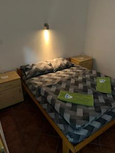 a bedroom with a bed with green towels on it at Nova Čubura in Šid