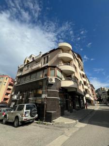 a building with a car parked in front of it at Sunny & Stylish Apartment in Vratsa