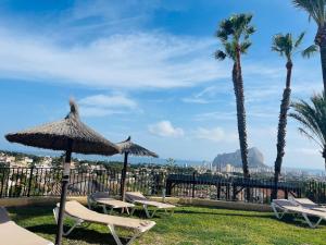 a group of chairs and umbrellas and palm trees at Toller Bungalow & Panoramasicht Imperial Park Calpe in Calpe