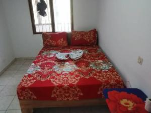 un letto rosso con due bicchieri sopra di Beau séjour fadilimmo a Yaoundé