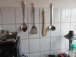 una cucina con utensili appesi a un muro di Beau séjour fadilimmo a Yaoundé Altre 3 foto