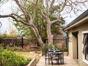 a group of tables and chairs next to a tree at Colenso Lodge B&B in Colenso