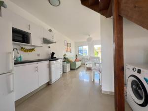 a kitchen with white cabinets and a washer and dryer at Caribbean Beach Resort 3, Piscadera - Casa D'Oro in Sint Michiel