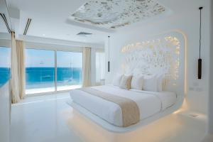 沙姆沙伊赫Meraki Resort Sharm El Sheikh Adults only的一间带床和大窗户的白色卧室