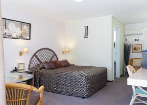 a bedroom with a bed and a table and chairs at Raceways Motel in Brisbane