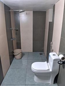 a bathroom with a white toilet and a shower at Vintage valley Heritage home in Thodupuzha