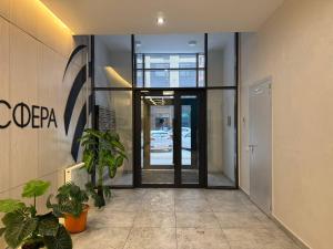 an entrance to an office with a door and plants at Atmosfera Comfort in Taldykolʼ +13 photos