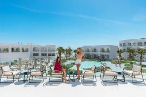 沙姆沙伊赫Meraki Resort Sharm El Sheikh Adults only的两名妇女站在度假村的庭院