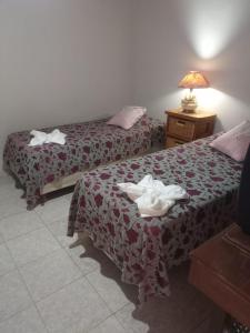 Dos camas en una habitación de hotel con toallas encima. en Departamento Adorable, Centro, con Cochera, en Villa Carlos Paz