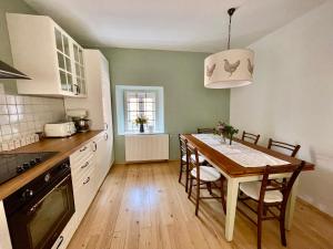 a kitchen with a wooden table and a dining room at Cozy country home Stefka in Mokronog