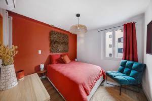 a red bedroom with a bed and a blue chair at Appartement T4 Carqueiranne in Carqueiranne