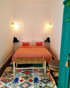 una camera da letto con un letto con lenzuola rosse e un tappeto di Riad bab Adam a Marrakech