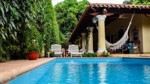 a swimming pool in front of a house with chairs at La Casona Hotel Boutique in Asunción