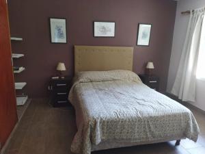 ein Schlafzimmer mit einem Bett und zwei Nachttischen mit Lampen in der Unterkunft Los Tres Soles in Mar del Plata