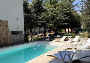 塔菲德尔瓦勒塔菲酒店的一座带白色躺椅的游泳池,位于大楼旁