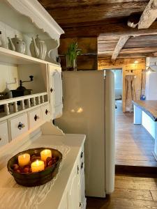 a kitchen with a white refrigerator and a bowl of candles at Fairytale cottage Francka in Gorica pri Slivnici +21 photos