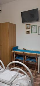 a room with a table and a tv on the wall at Bed and Breakfast Santa Elisa in Pero