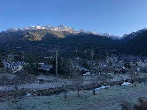 a view of a town with mountains in the background at El rincón de la Rapeda in Villanúa