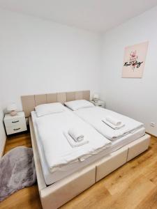 a large white bed in a white bedroom at Franco Piešťany Apartments 1 in Piešťany