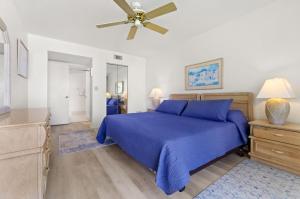 Un dormitorio con una cama azul y un ventilador de techo. en St. Pete Isla Bahia Vista 12-245 2BD, en Tierra Verde 36 fotos más