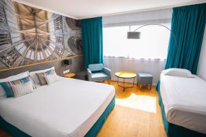 ein Hotelzimmer mit zwei Betten und einem Fenster in der Unterkunft Mercure Mont Saint Michel in Le Mont Saint Michel + 37 Fotos
