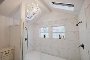 a bathroom with a shower and a chandelier at Stunning Victorian 3BR Sleeps 10 in San Antonio +45 photos