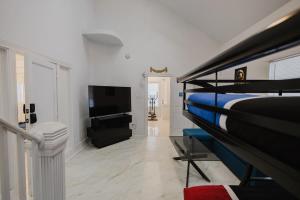 a bedroom with a bed and a flat screen tv at Stunning Victorian 3BR Sleeps 10 in San Antonio