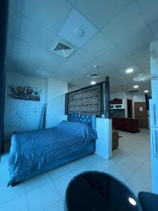 a bedroom with a blue bed in a room at Grand studio en plein centre-ville d'Oran in Oran +3 photos