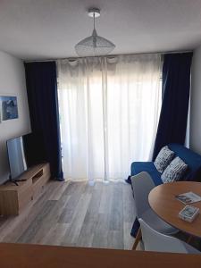 a living room with a blue couch and a table at Appartement Ciboure golf et Nivel in Ciboure