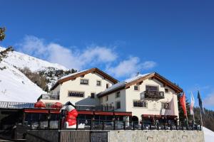 a building with a snow covered mountain in the background at Luxus Apartments Chesa Chantarella an TOP Lage! in St. Moritz