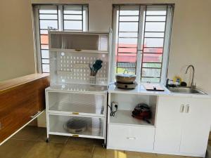 a kitchen with a white refrigerator and a sink at Didou Homestay Đông Anh in Dong Anh