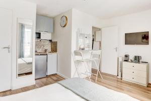 a white room with a bed and a kitchen at Le Courcillon Calme, Cour privée & Proche Château in Versailles
