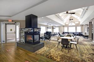 a lobby with a fireplace and a table and chairs at Residence Inn Louisville Airport in Louisville