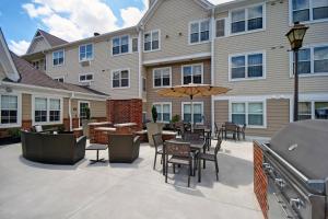 a patio with a table and chairs and an umbrella at Residence Inn Louisville Airport in Louisville