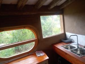 a kitchen with two windows and a sink at Tierra Colibrí in Punta Colorada