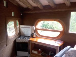 a small kitchen with a stove and two windows at Tierra Colibrí in Punta Colorada +18 photos
