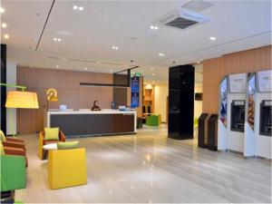 a lobby of a store with yellow and green chairs at IU Hotel Beijing West Coach Station Liuliqiao East Metro Station in Beijing